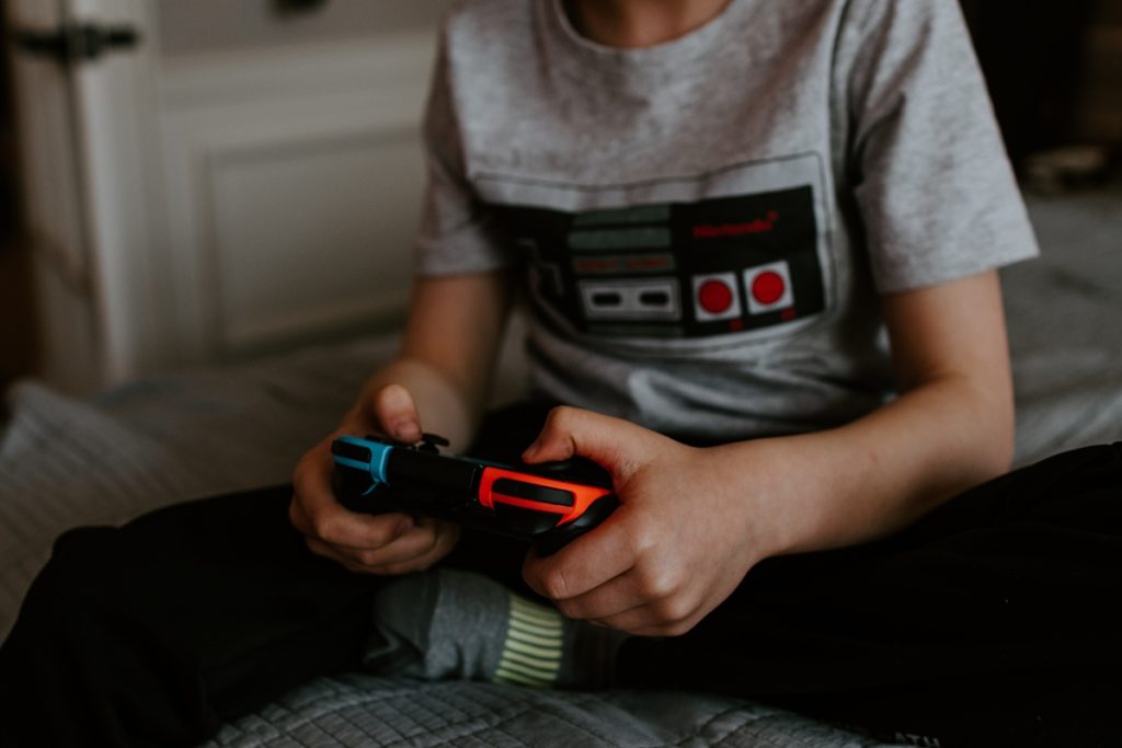 Child gamer playing video game. Photo by Kelly Sikkema on Unsplash