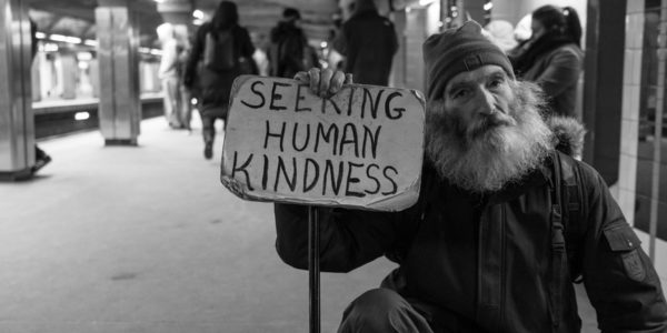 Homeless man seeking human kindness. Photo by Matt Collamer on Unsplash