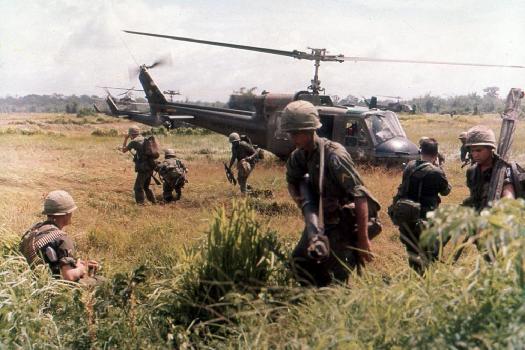 Troops disembark from a helicopter during the Vietnam War