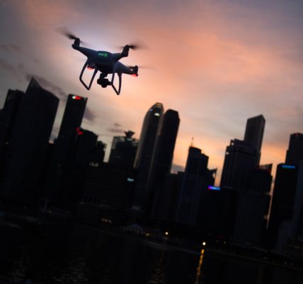 Drone over city skyline silhouette. Photo by Goh Rhy Yan on Unsplash