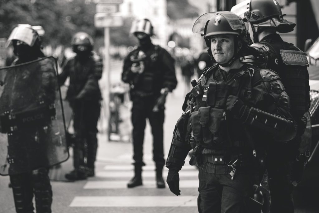 Greyscale armed French police. Photo by ev on Unsplash