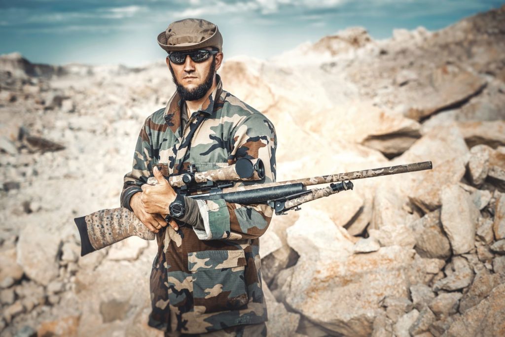 Irregular warrior: unmarked soldier with rifle. Photo by Maxim Potkin on Unsplash